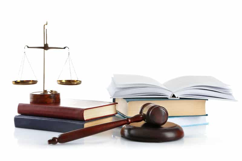 Wooden gavel, justice scales and books for code violations