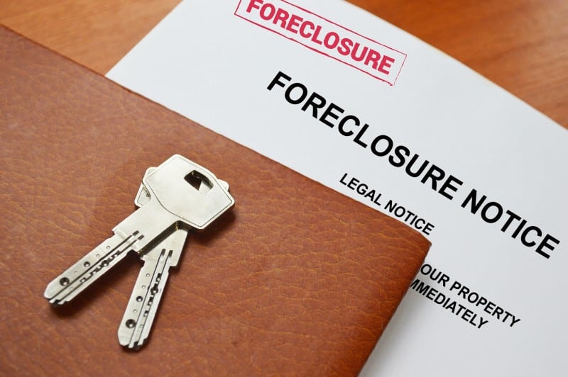 A document labeled “foreclosure”, a folder and some keys.